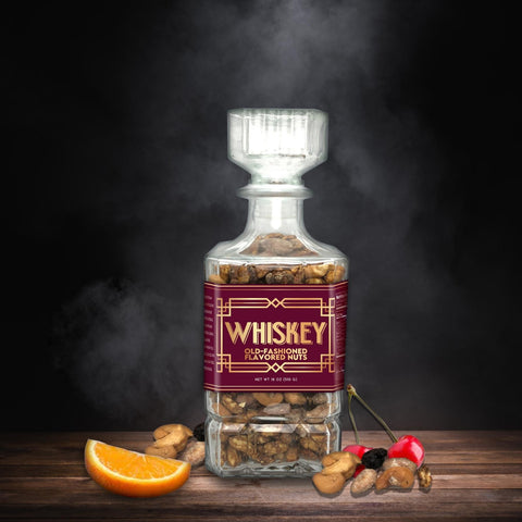 Whiskey Old-Fashioned flavored nuts in glass decanter with orange and cherry garnishes.