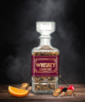 Whiskey Old-Fashioned flavored nuts in glass decanter with orange and cherry garnishes.