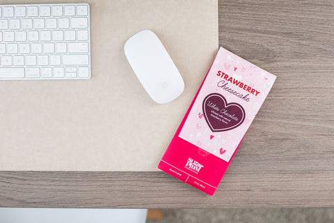 Strawberry Cheesecake White Chocolate Bar on a Desk Next to a Keyboard and Mouse