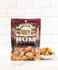 Rum flavored gourmet peanuts in a bag, part of a liquor-inspired snack collection, with a bowl of peanuts on a white surface.