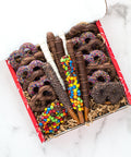 Assorted chocolate-covered pretzel gift box with colorful toppings, perfect for gifting and holiday treats.