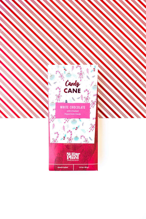 Candy Cane White Chocolate Bar packaging with festive peppermint design, set against red and white striped background.