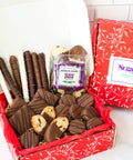 Gourmet chocolate gift box with assorted hand-dipped treats including chocolate-covered potato chips, cookies, and pretzels.