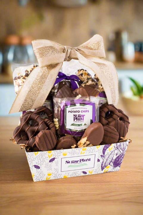 Chocolate Mountain Gift Basket by Sugar Plum with assorted handcrafted chocolates and snacks, wrapped with a bow.