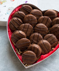 Heart-shaped box of handcrafted milk chocolate-covered peanut butter cracker cookies, perfect sweet and salty treat.