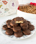 Milk chocolate-covered peanut butter cracker cookies on a plate, with a heart-shaped box in the background.