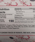 Nutrition facts label of Candy Cane White Chocolate Bar showing ingredients and allergens on a holiday-themed background.