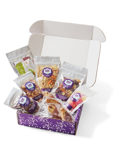 Gourmet snacks in Sugar Plum Comfort Box, perfect for sympathy or get-well gift, featuring sweet and salty treats in open package.