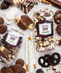Assorted gourmet chocolates and snacks from Sugar Plum, featuring dark, milk, and white chocolate-covered treats in a holiday gift box display.