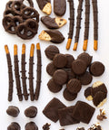 Gourmet assortment of handcrafted dark chocolate-covered snacks from Sugar Plum's gift box, featuring pretzels, cookies, and more.