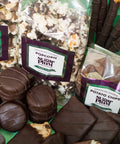 Gourmet dark chocolate gift box with popcorn and potato chips, offering a 42-piece assortment of handcrafted snacks for special occasions.