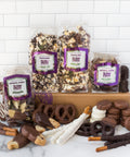 Gourmet chocolate assortment with pretzels and popcorn, featuring dark, milk, and white chocolate snacks in Sugar Plum's gift box.