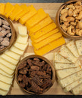 Gourmet cheese and nuts platter featuring sharp cheddar, Monterey Jack, and roasted nuts, perfect for charcuterie and wine pairing.