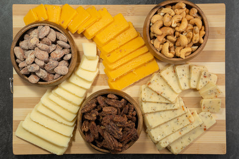 Gourmet cheese and nuts platter featuring sharp cheddar, Monterey Jack, and roasted nuts, perfect for charcuterie and wine pairing.