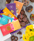 Nostalgic Chocolate Bar Gift Box with assorted handcrafted treats, colorful packaging, and vibrant flowers; perfect for all occasions.