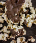 Chocolate-covered gourmet popcorn with milk and dark chocolate drizzles, showcasing a sweet and salty snack blend.
