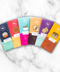 Nostalgic Chocolate Bars 6 Pack in childhood-inspired flavors, displayed on a marble surface.