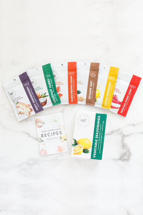 Veggie Lover's Cooking Spice Kit with six global spice packets and plant-based recipe book on a marble surface