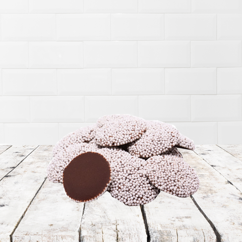 Assorted milk and white chocolate treats on a rustic wooden table, part of a thoughtful Get Well Soon Box care package.