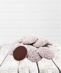 Assorted milk and white chocolate treats on a rustic wooden table, part of a thoughtful Get Well Soon Box care package.