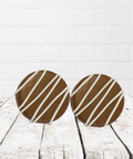 Milk chocolate cookies with white chocolate drizzle on rustic wood background
