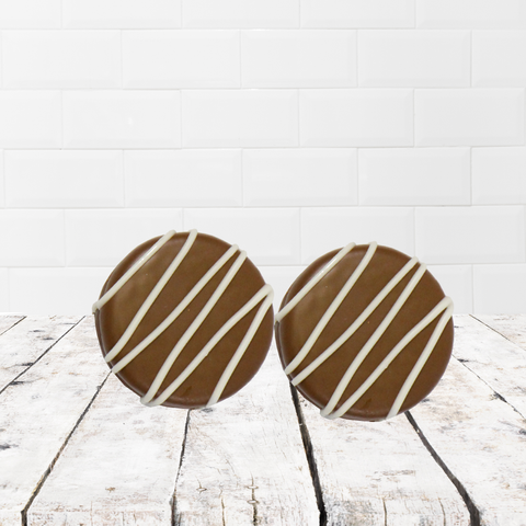 Milk chocolate cookies with white chocolate drizzle on rustic wood background