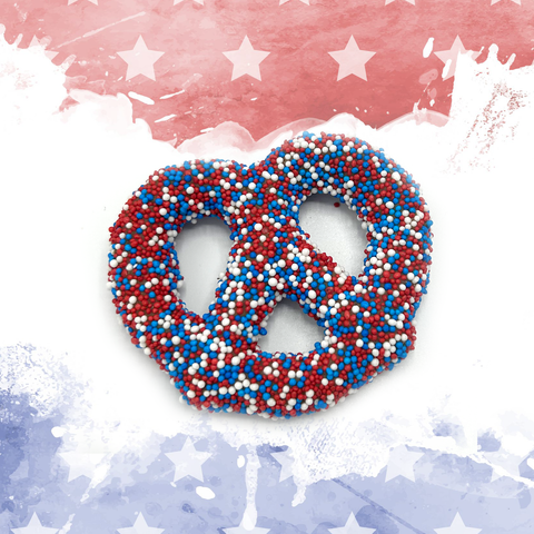 Festive red, white, and blue chocolate-covered pretzel with sprinkles on a patriotic background.