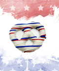 Patriotic chocolate-covered pretzel with red, white, and blue drizzle on a festive starry background.