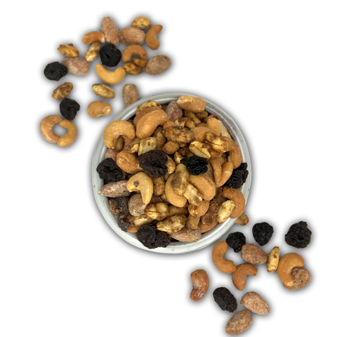 Whiskey Old-Fashioned flavored nuts in a bowl with scattered nuts on a black background.
