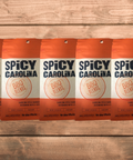 Five packs of Spicy Carolina BBQ Seasoning on a wooden surface