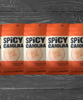 Five packs of Spicy Carolina BBQ Seasoning on a wooden surface, showcasing vinegar and pepper-based BBQ blends for grilling and marinades.