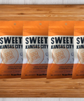 Sweet Kansas City BBQ Seasoning 5 Pack on wooden table, featuring handcrafted barbecue blend packaging.