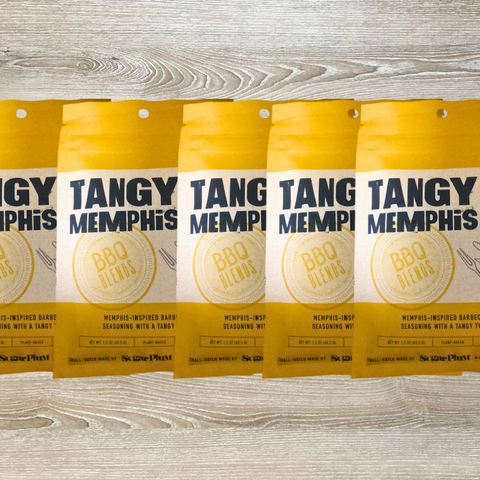 Five packs of Tangy Memphis BBQ Seasoning on a wooden surface, perfect for enhancing pork ribs and brisket with a sweet and spicy flavor.