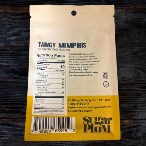 Back of Tangy Memphis BBQ Seasoning pack showing ingredients and nutrition facts on wooden background.
