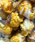 Gourmet caramel corn drizzled with white and milk chocolate, showcasing a sweet and crunchy handcrafted snack.